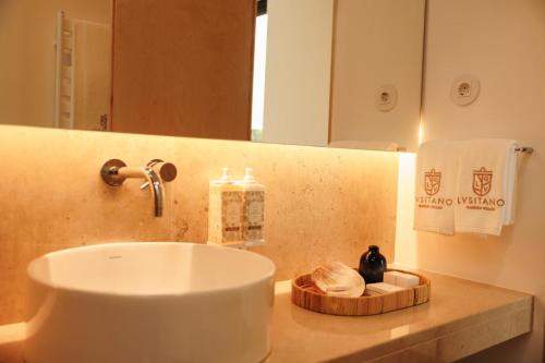 a bathroom with a sink and a mirror at Lusitano Garden Villas in Ponta Delgada