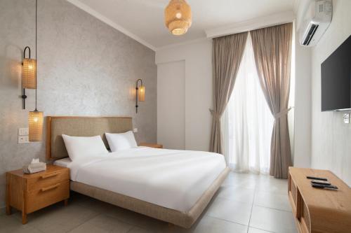 a bedroom with a large white bed and a window at Ios Hotel & Village Extension in El Alamein