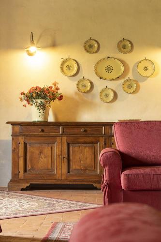 a table with a vase on a wall with clocks at Cortona Resort-Le Terre Dei Cavalieri in Cortona