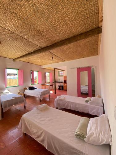 a large room with three beds and a room with at Pousada Casa Matriz in Itabirito