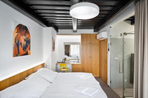 a bedroom with a large bed and a bathroom at Fancy apartments by Prague Castle in Prague