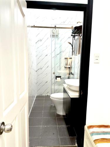 a bathroom with a white toilet and a sink at Nemaru urban stay in Ho Chi Minh City