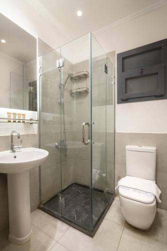 a bathroom with a shower and a toilet and a sink at Ios Hotel & Village Extension in El Alamein