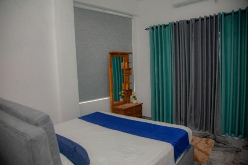 una camera da letto con un letto, una sedia e una finestra di Celenika Resort a Kandy