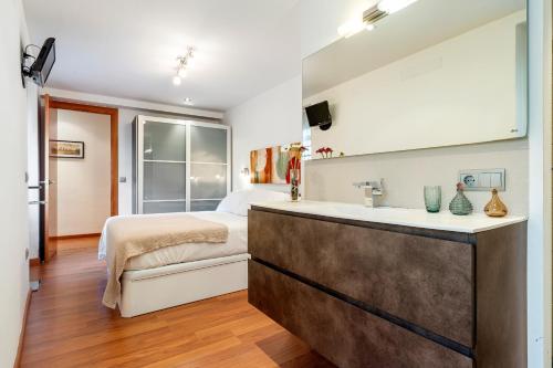 a bedroom with a bed and a sink at Hauzify I Apartaments La Plaça in Montblanc