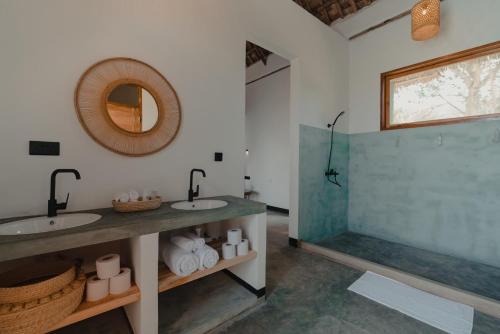 a bathroom with two sinks and a shower at Foot On Africa Safari Lodge in Mto wa Mbu