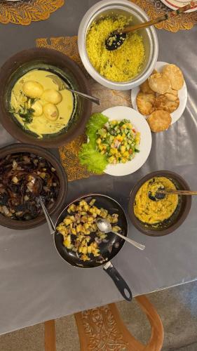 a table with several bowls of food on it at Rose Palace in Nuwara Eliya