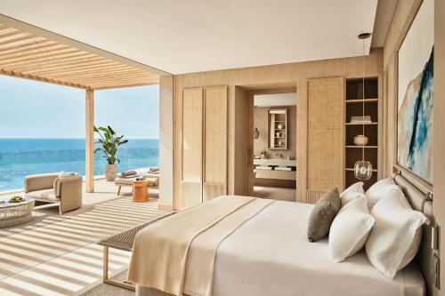 a bedroom with a bed and a view of the ocean at Ikos Andalusia in Estepona