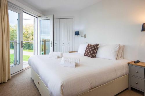 a bedroom with a large white bed with a window at The Landings 19, Scout on the Water - P in South Cerney