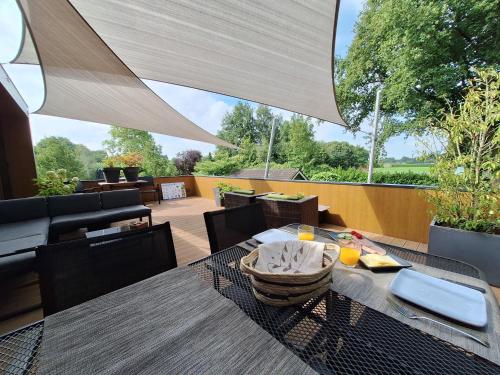 a patio with a table and chairs and a patio with a view at B&B Vierlingsbeek, Appartement en tuin-chalets in Vierlingsbeek