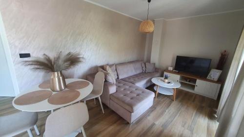a living room with a table and a couch at Apartmani Drinske ploce in Bajina Bašta