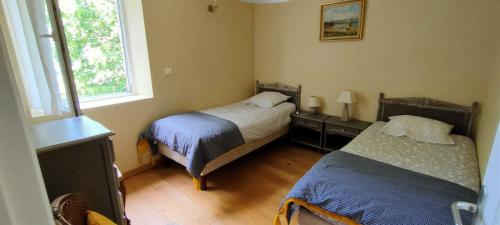 a bedroom with two beds and a window at Gîte La Ferme De Musan in Chatuzange-le-Goubet