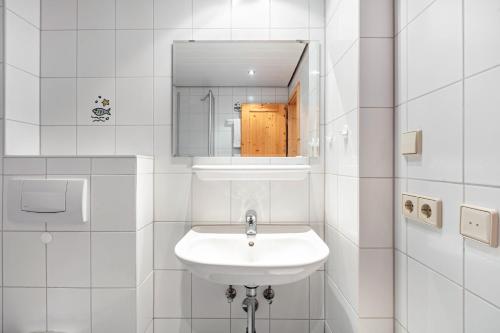 a white bathroom with a sink and a mirror at Pension Birgit in Todtnauberg