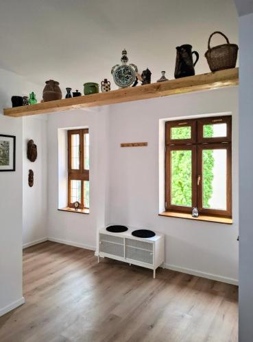 an empty room with a table and two windows at Casa de pe colț in Orăştie
