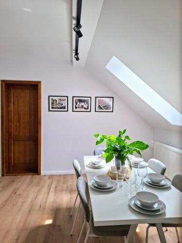 a white dining room with a white table and chairs at Casa de pe colț in Orăştie