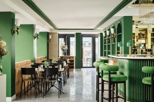 a restaurant with green walls and bar stools at Hotel Observatoire Luxembourg in Paris