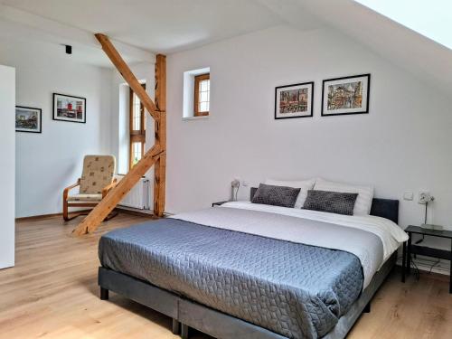 a bedroom with a large bed and a chair at Casa de pe colț in Orăştie