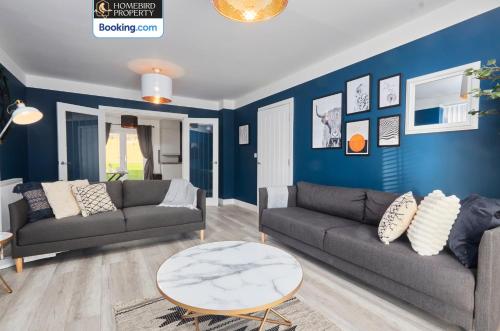 a living room with two couches and a blue wall at Luxurious 4Bedroom House By Homebird Property Management Short Lets & Serviced Accommodation Leeds With Private Parking, Garden & Patio Area in Leeds