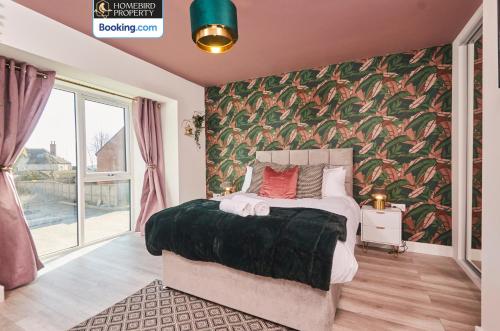 a bedroom with a large bed with a floral wallpaper at Luxurious 4Bedroom House By Homebird Property Management Short Lets & Serviced Accommodation Leeds With Private Parking, Garden & Patio Area in Leeds