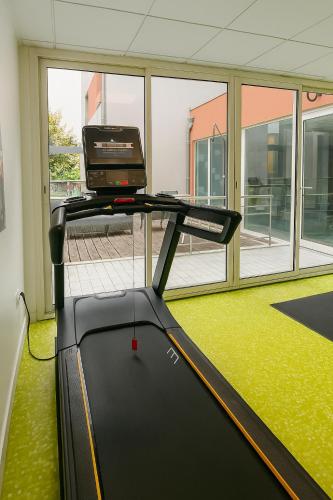 a treadmill in a room with a large window at Kyriad Clermont-Ferrand-Sud - La Pardieu in Clermont-Ferrand