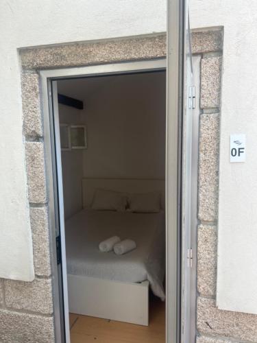 a bedroom with a bed inside of a glass door at Relógio Guest House in Porto