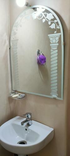 a bathroom with a white sink and a mirror at Atlas Pearl in Aguersioual