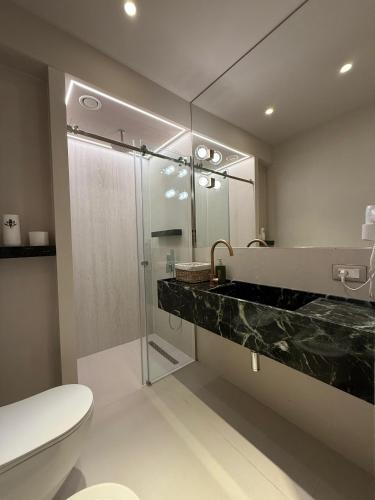 a bathroom with a shower and a toilet and a sink at Nava Sol Apartment in Vlorë