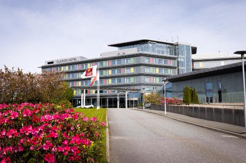 a office building with pink flowers in front of it at Clarion Hotel Bergen Airport in Bergen
