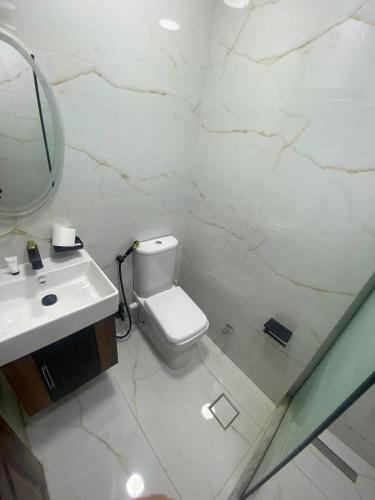 a white bathroom with a toilet and a sink at secret of pyramids view in Cairo