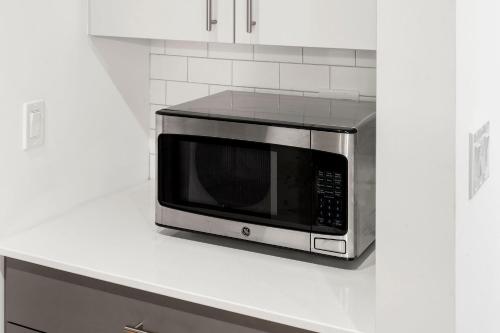 a microwave sitting on top of a kitchen counter at City Studio Escape Bright Sleek & Modern in Chicago