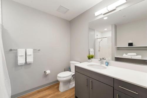a white bathroom with a toilet and a sink at City Studio Escape Bright Sleek & Modern in Chicago