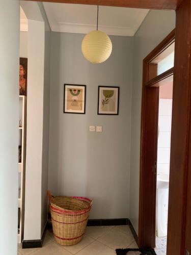 a hallway with a wicker basket and a light fixture at Angello Apartment in Kira