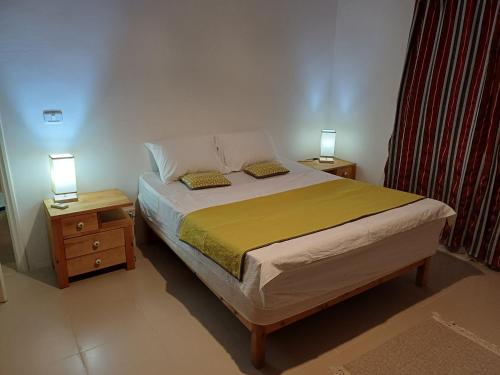 a bedroom with a bed and two night stands with lamps at Baraka in Aghīr