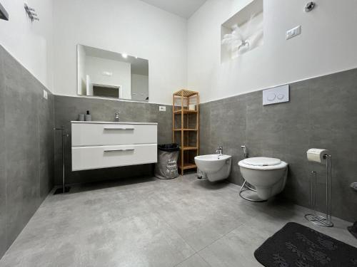 un bagno con lavandino, WC e specchio di La casetta della piazza a Carovigno