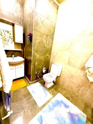 a bathroom with a toilet and a shower and a sink at Boulevard Tashkent City 02 in Tashkent