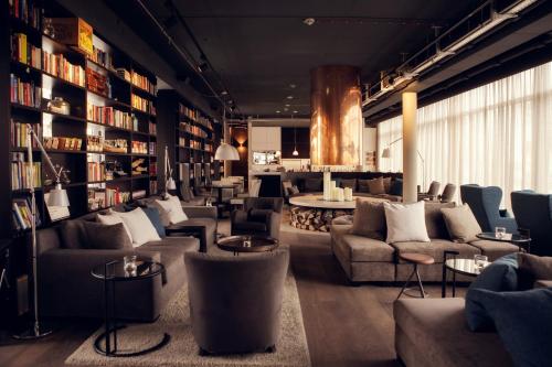 a library with couches and tables and books at Soulmade in Garching bei München