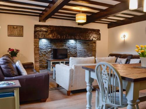 Una sala de estar con un sofá y una chimenea. en The Old Farmhouse, en Blakeney