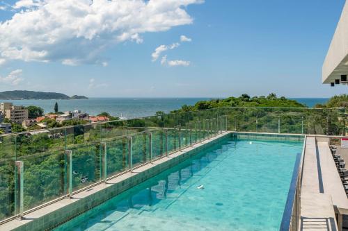 a swimming pool with a view of the ocean at Apartamento 509 com piscina Aquecida in Bombinhas