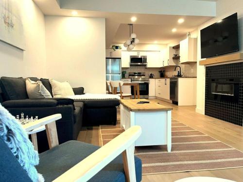 a living room with a couch and a table at Cedar & Sage Suite - Kitchen & Comfort in Victoria