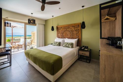a bedroom with a bed and a balcony at Pepper Sea Club Hotel in Georgioupolis