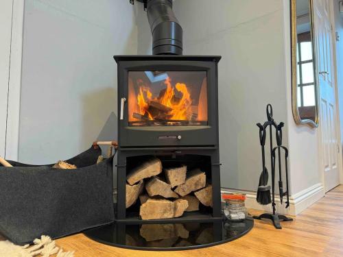 a stove with a fire in a living room at The Annexe @ Mandalay Lodge in Medstead