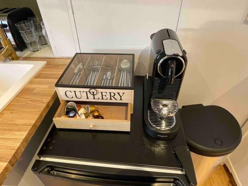 a kitchen counter with a grinder and a box of utensils at The Annexe @ Mandalay Lodge in Medstead