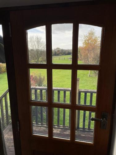 a door with a window looking out at a field at The Annexe @ Mandalay Lodge in Medstead