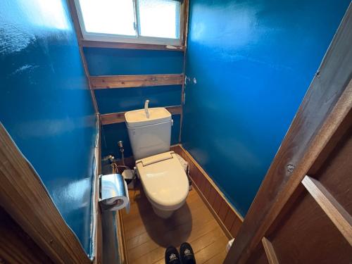 a bathroom with a toilet in a blue room at 木の家ゲストハウス前橋5号館 in Maebashi