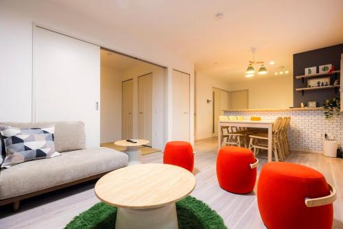 a living room with a couch and a table and chairs at Amp Flat Dazaifu Ishizaka in Dazaifu