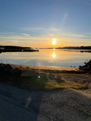 a sunset over a body of water with at Strand 18b in Grebbestad