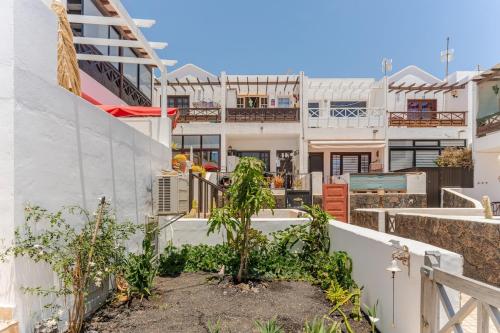 a house with a courtyard with trees in it at Amanecer Breia Apartment in Tías