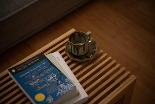a book and a tea pot sitting on a table at kotinoma kuu in Hakozaki