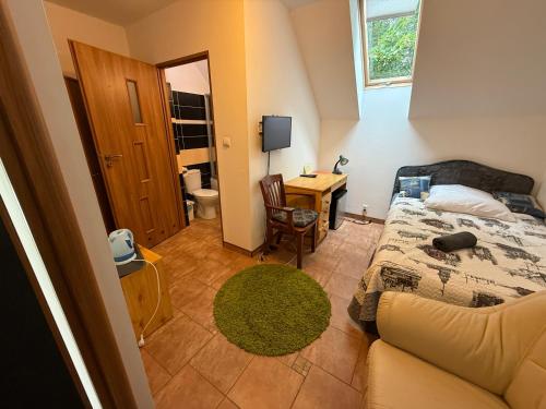 a bedroom with a bed and a desk and a couch at VITA Augustów in Augustów