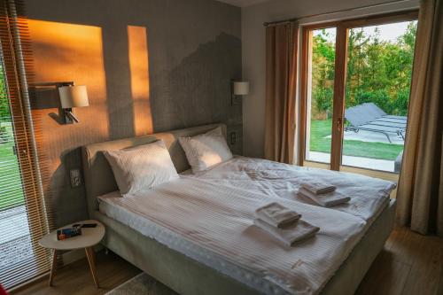 a bedroom with a bed with towels on it at Przystań Spokoju in Chmielno